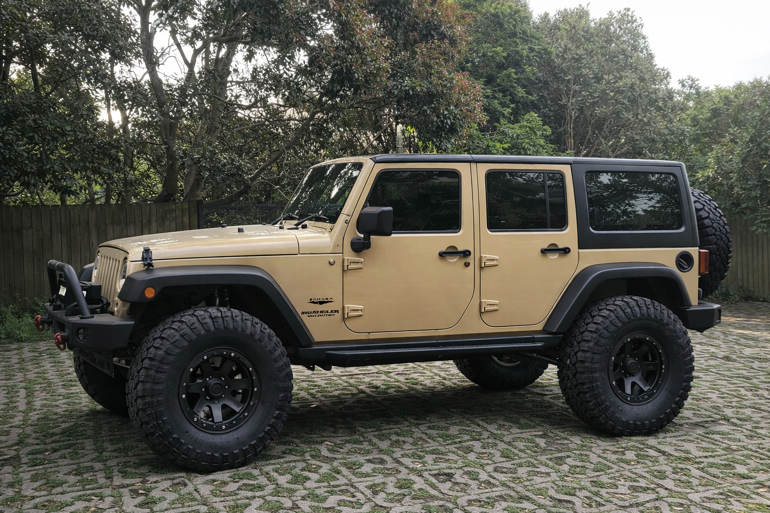 Tan Jeep Wrangler JK Unlimited lifted with black wheels